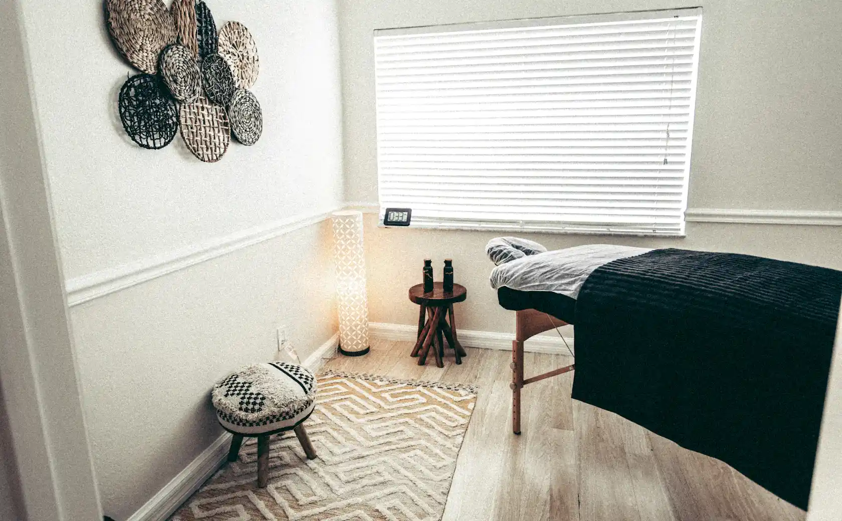 Private treatment studio ready for a session: couch made up with clean linen and warm light